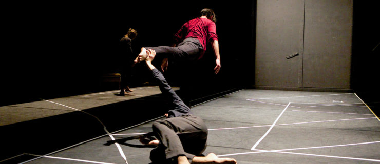 two dancers performing on dimly lit stage