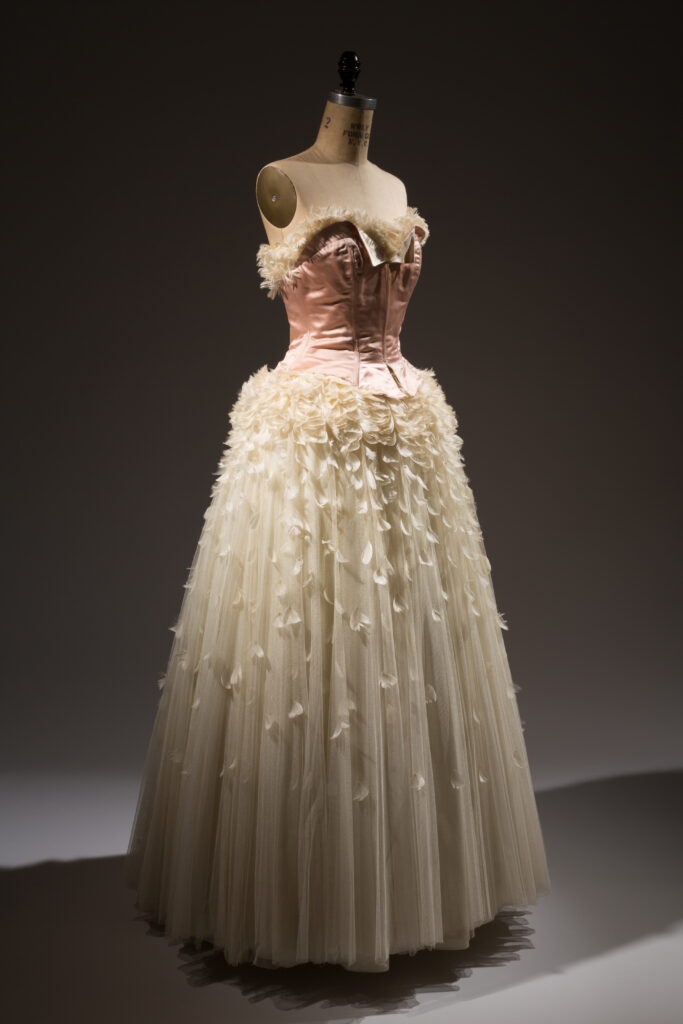 a long tulle dress that is pink and white on a mannequin 