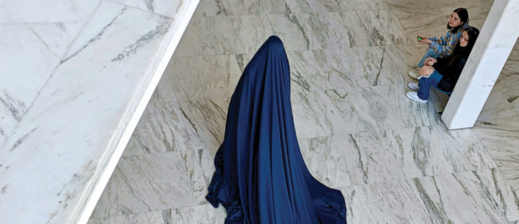 dancer covered in blue sheet dancing on marbled floor