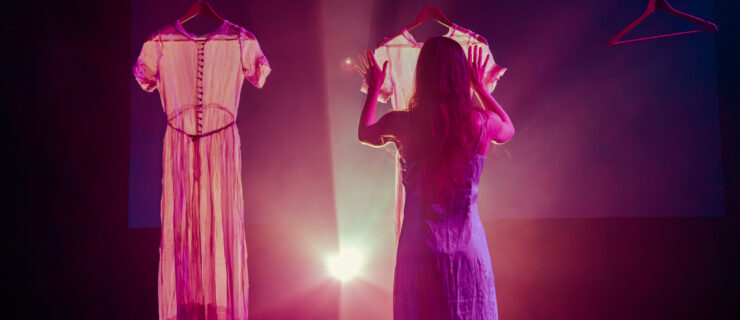 a female dancer hanging up a white dress on stage