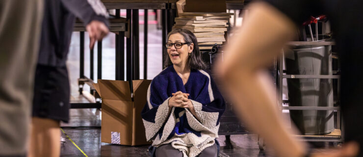 a woman sitting on the floor watching rehearsal