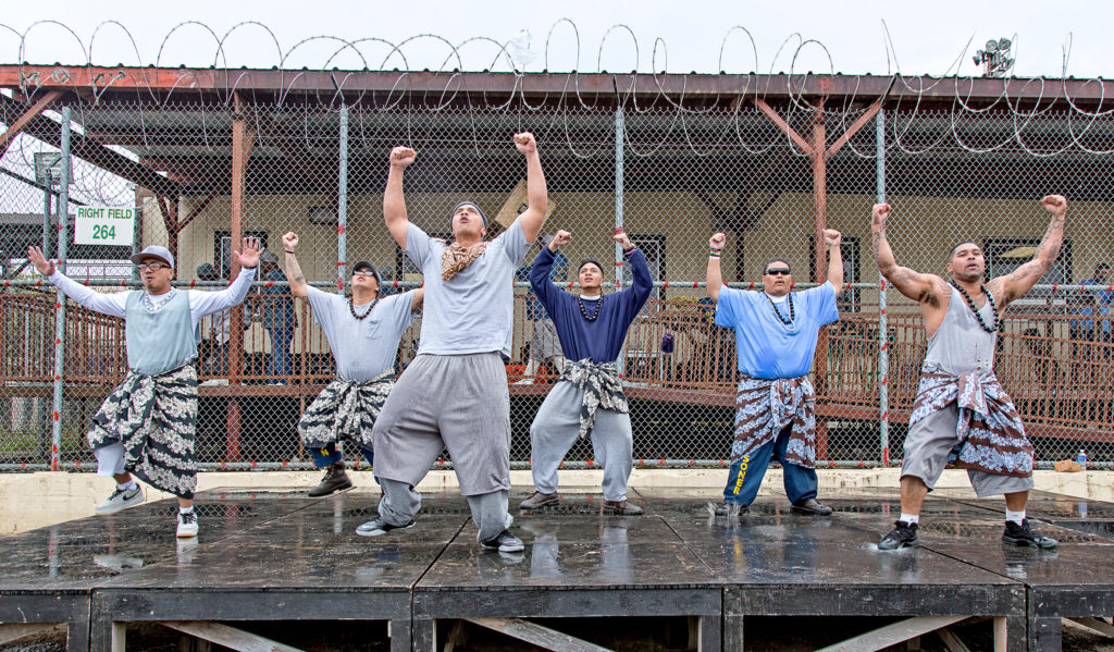 a group of male dancers arms over head