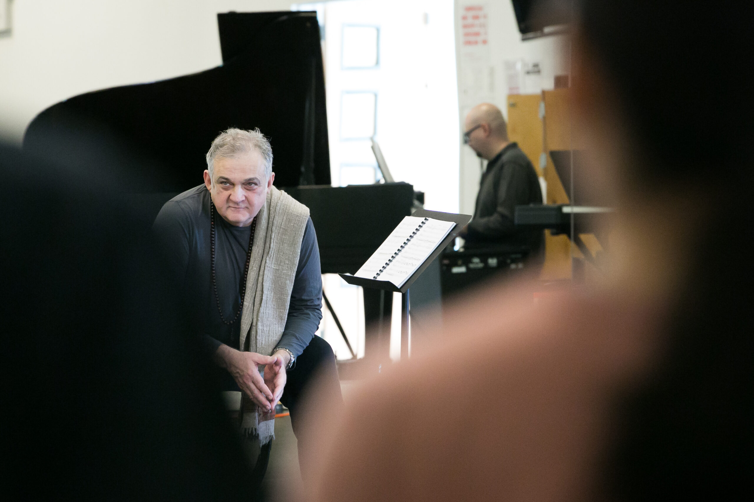 an older man sitting near piano