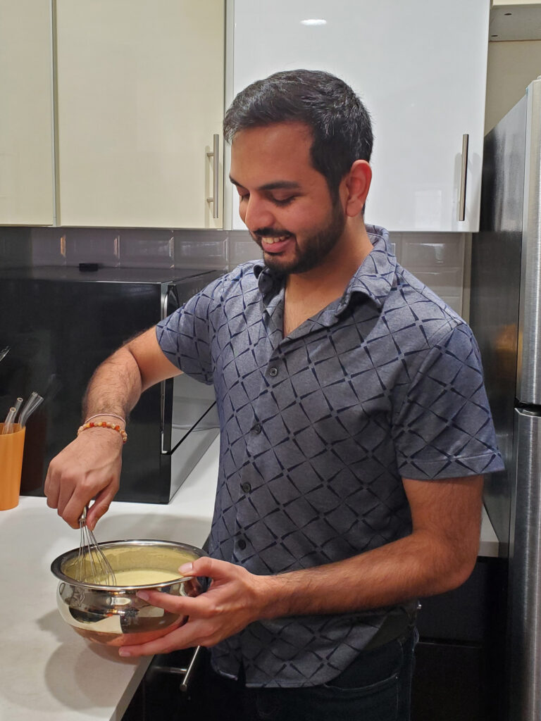 a man whisking a metal bowl in his kitchen 