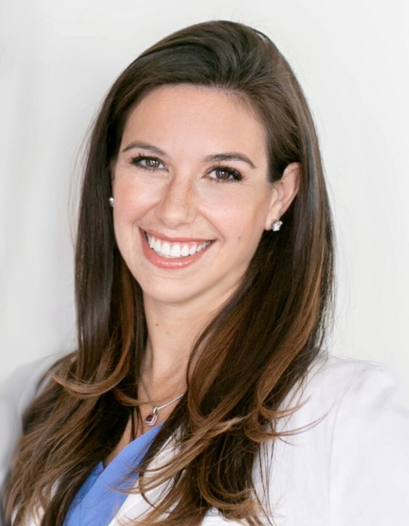 a woman with brown hair smiling at the camera