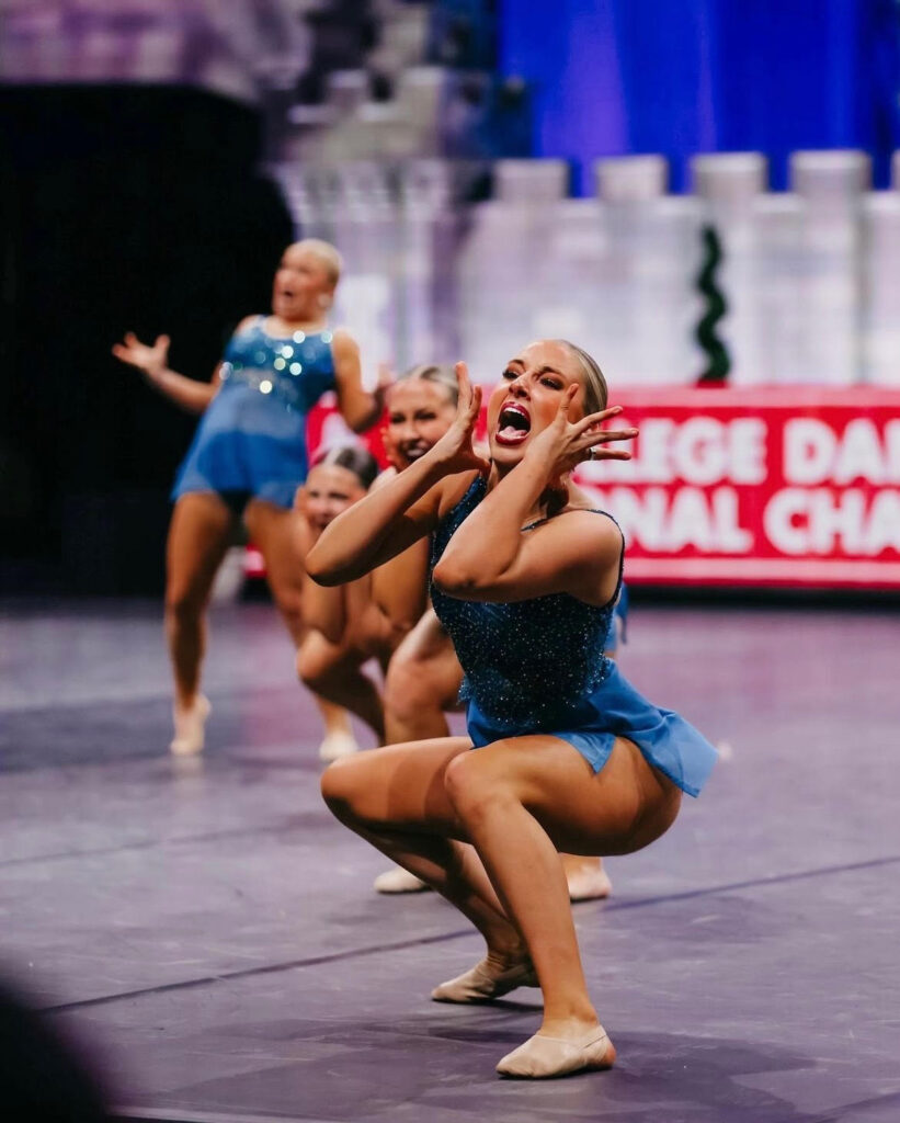 a female dancer wearing blue posing dramatically on stage 