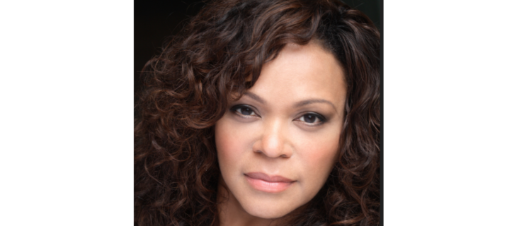 a woman with curly, long hair looking at the camera