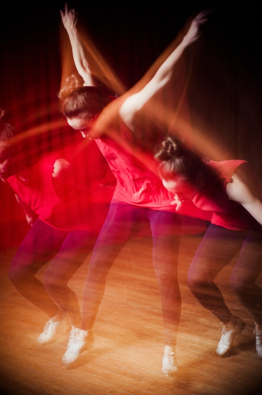 Michelle Dorrance is a blur of motion, multiple blurred images of her overlapping in one shot as she taps on a wooden floor.